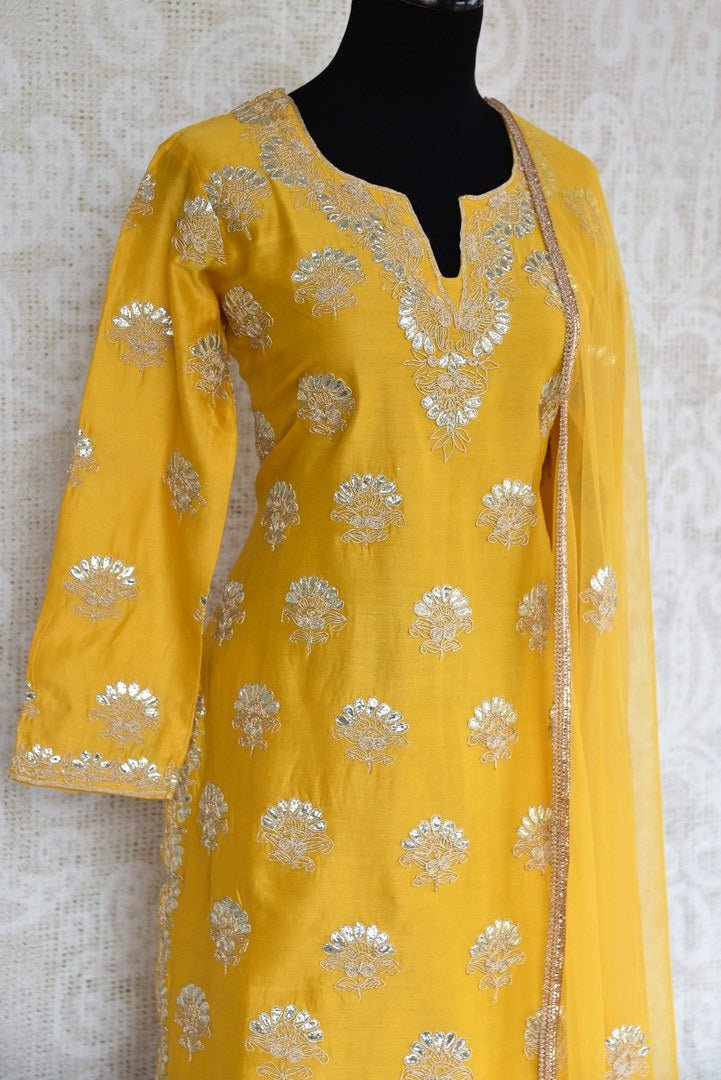 Buy yellow gota patti embroidery sharara suit with dupatta online in USA. The traditional outfit is a stunning choice for parties and special occasions. Get floored by an exclusive collection of Indian designer suits in USA available at Pure Elegance clothing store or shop online.-side view