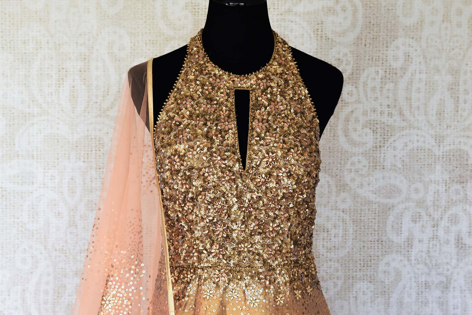 Leave them gaping in awe as you strut in this scintillating gold silk floor-length dress. The sequins embroidered on the dress complemented with a halter neck and peach sequin work dupatta looks spectacular Shop designer anarkali suits, concept sarees, indowestern dresses online or visit Pure Elegance store, USA. -front
