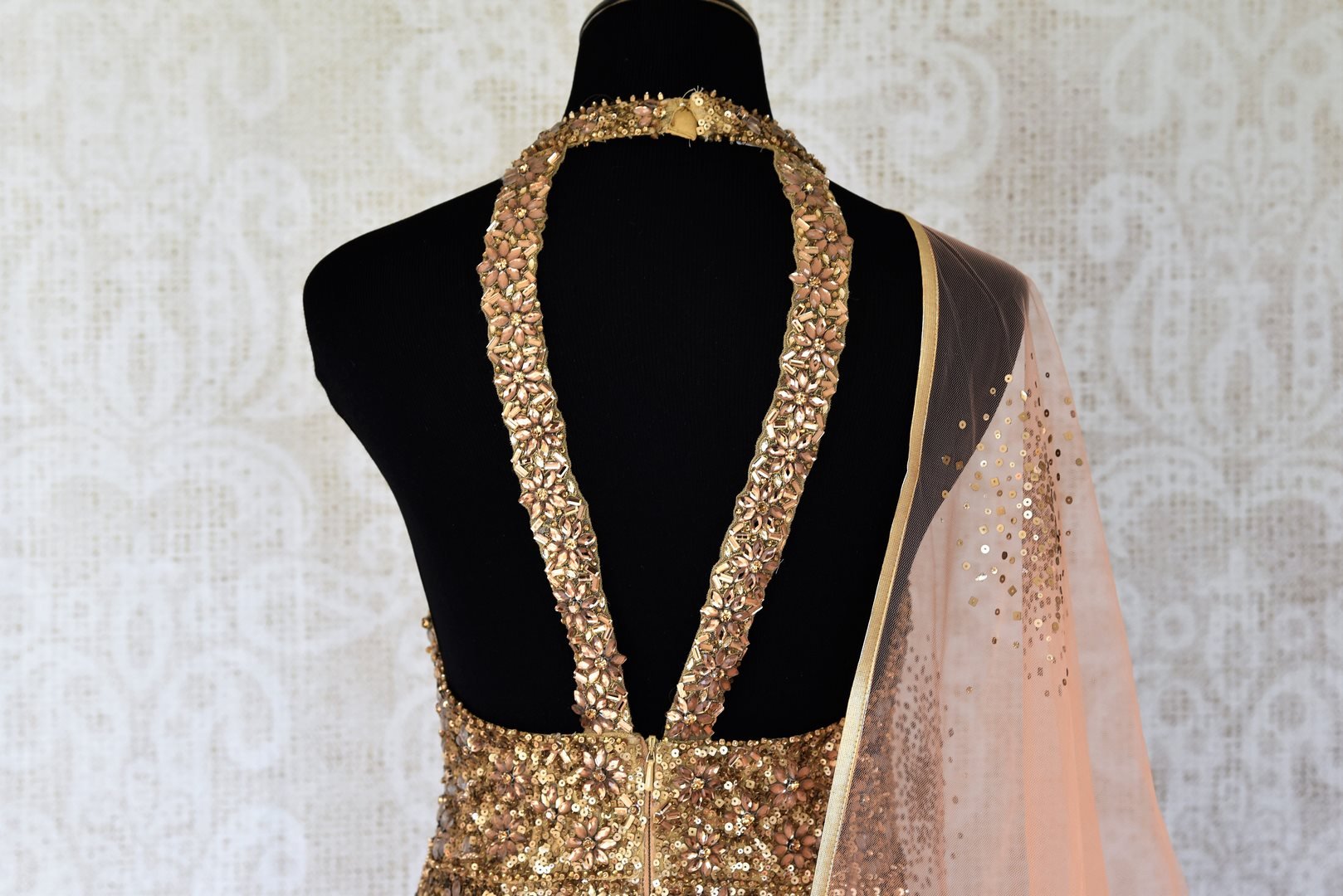 Leave them gaping in awe as you strut in this scintillating gold silk floor-length dress. The sequins embroidered on the dress complemented with a halter neck and peach sequin work dupatta looks spectacular Shop designer anarkali suits, concept sarees, indowestern dresses online or visit Pure Elegance store, USA. -back