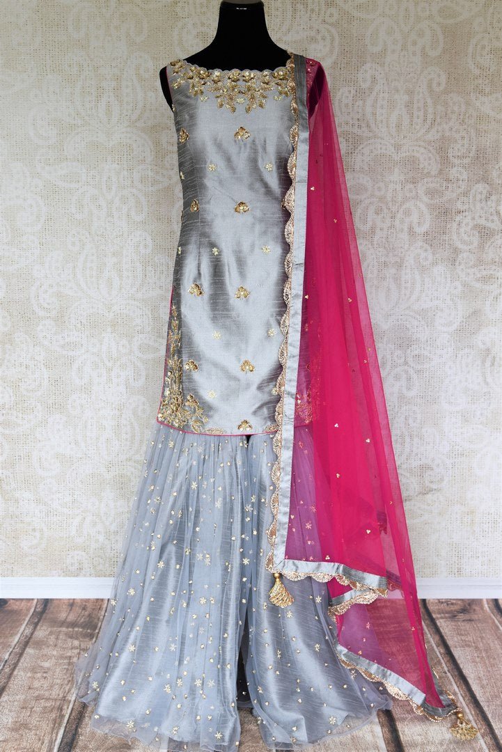 Be a muse in this pretty ash grey silk embroidered designer shararas with a dazzling grey embroidered kurta. The stunning zari embroidery coupled with a contrasting pink embellished dupatta with tassels hanging on its corners looks heavenly. Shop such beautiful Indian dresses, lehengas online or visit Pure Elegance store, USA. -full view