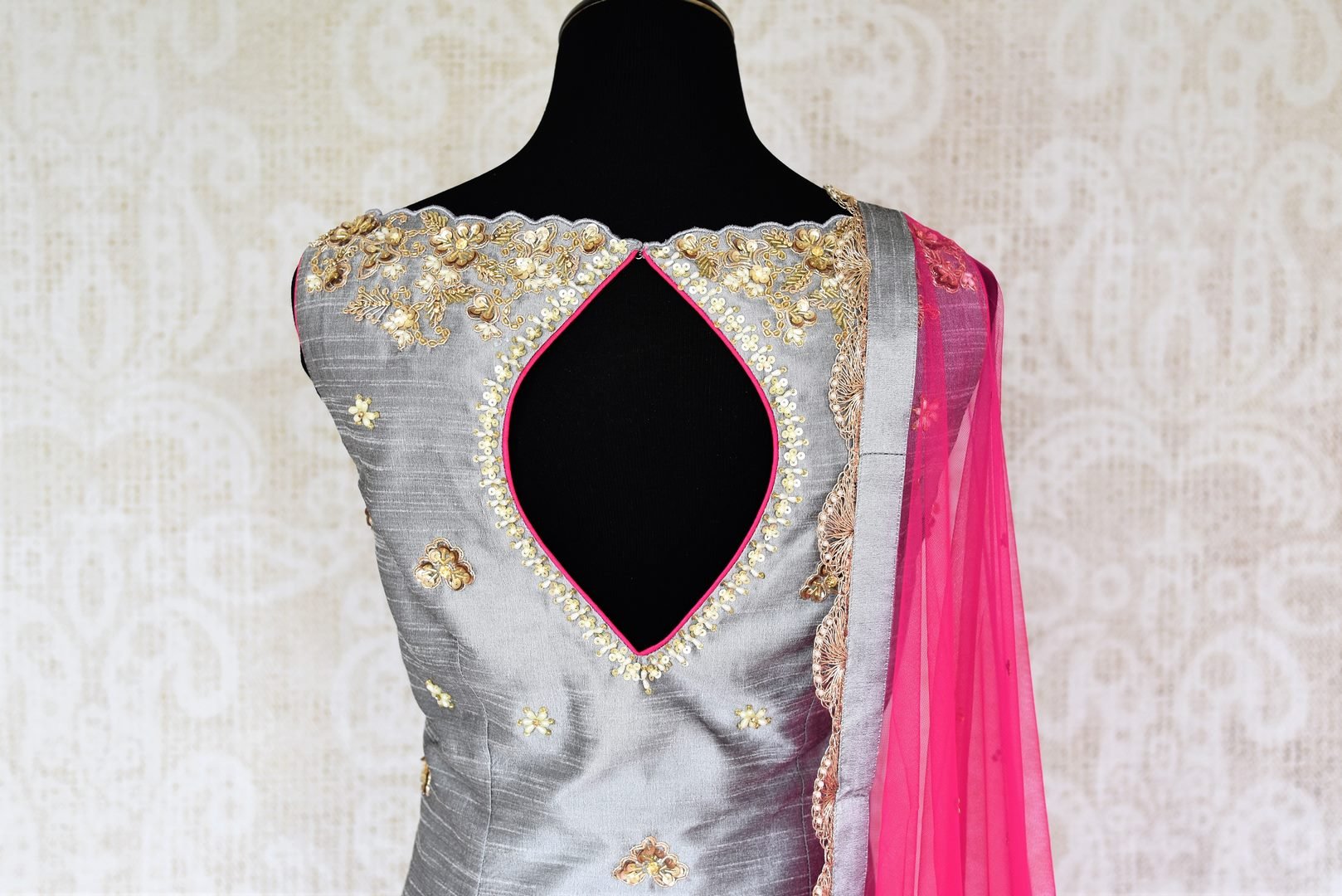 Be a muse in this pretty ash grey silk embroidered designer shararas with a dazzling grey embroidered kurta. The stunning zari embroidery coupled with a contrasting pink embellished dupatta with tassels hanging on its corners looks heavenly. Shop such beautiful Indian dresses, lehengas online or visit Pure Elegance store, USA. -suit back