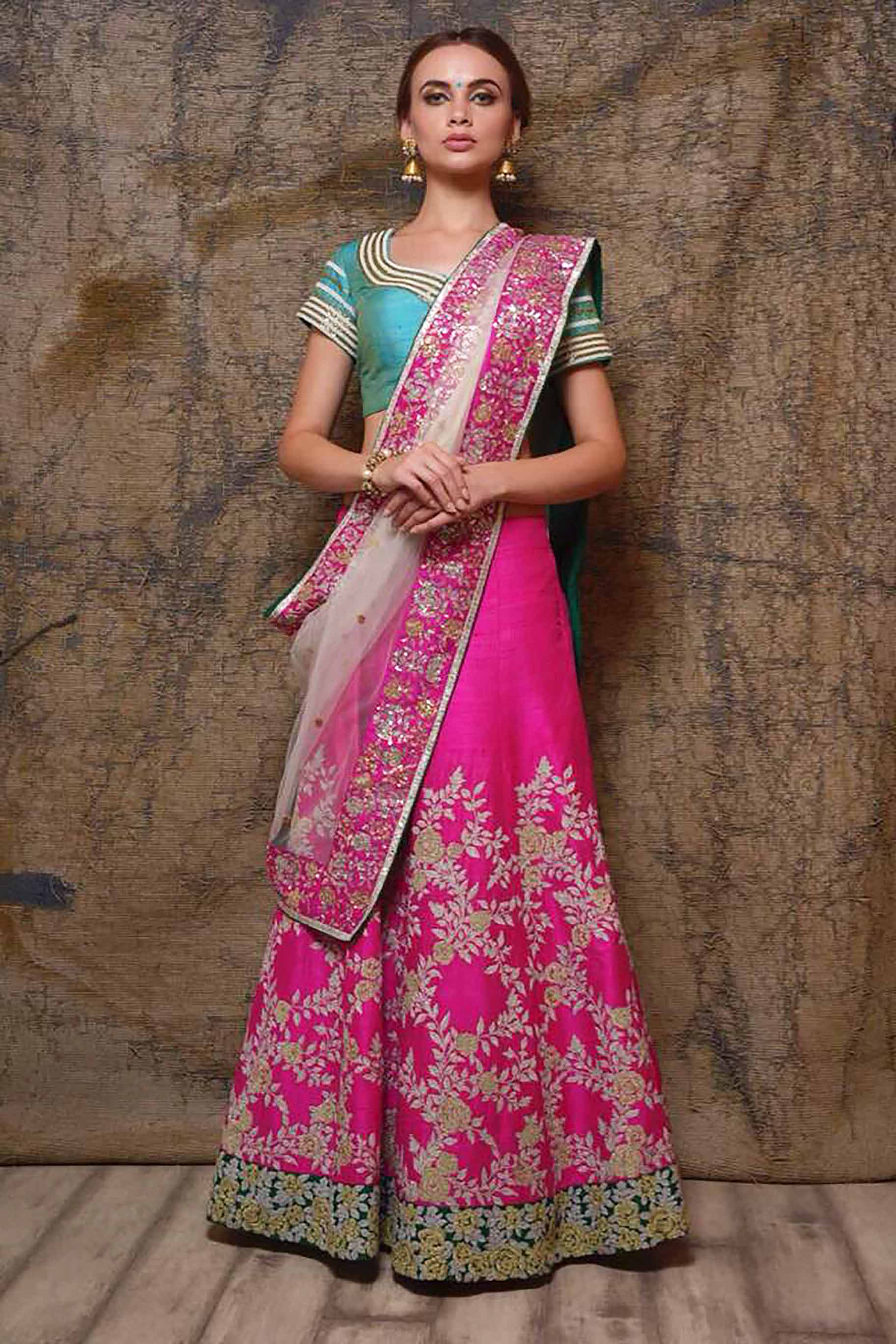 Buy hot pink raw silk embroidered lehenga online in USA with blue choli. Shine in rich silhouettes of exquisite Indian designer wedding lehengas from Pure Elegance Indian clothing store for women in USA or shop online.-front view
