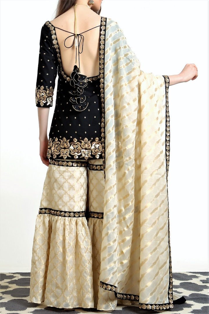 Buy black silk blend short kurta with ivory tissue net gharara online in USA. Get occasion ready with a stunning range of Indian designer suits from Pure Elegance fashion store in USA. We bring the best designer dresses for Indian women in USA at our online store. Shop now.-back