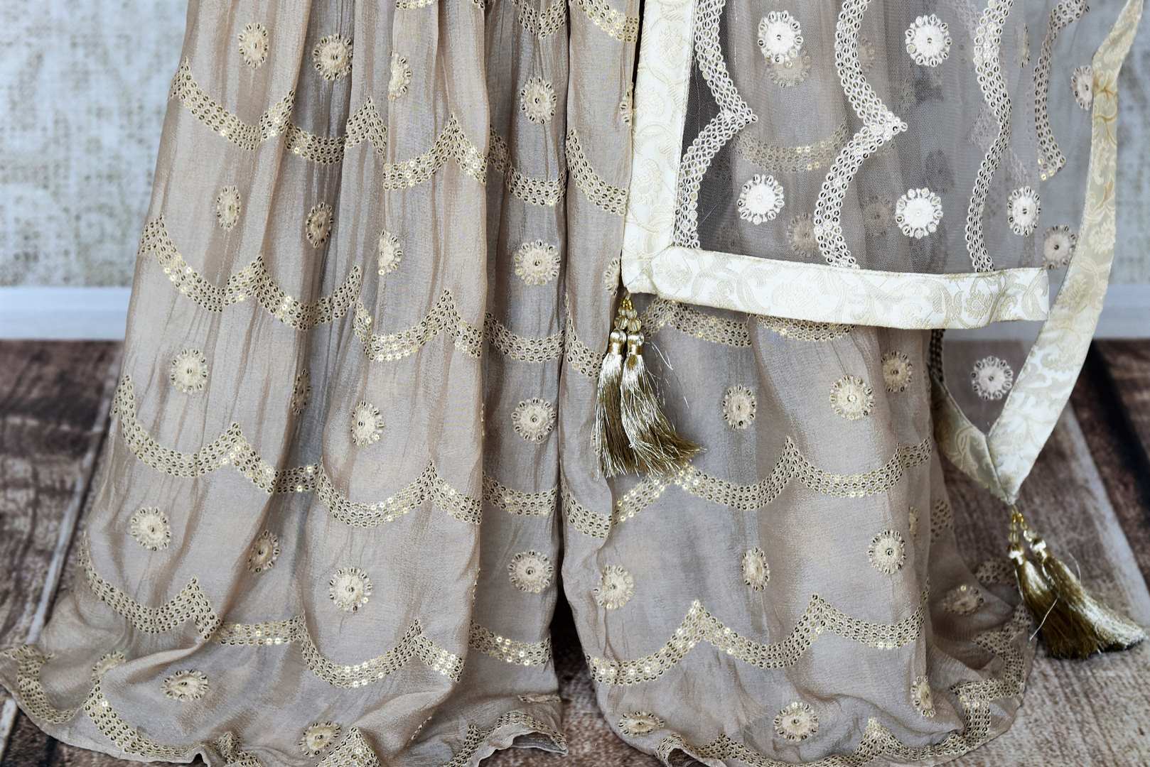 Shop cream embroidered Banarasi silk suit online in USA with grey silk sharara. Keep your wardrobe update with latest Indian clothing from Pure Elegance Indian fashion store in USA. Shop beautiful Indian designer lehengas, Anarkali suits, gowns for Indian women in USA from our online store.-bottom