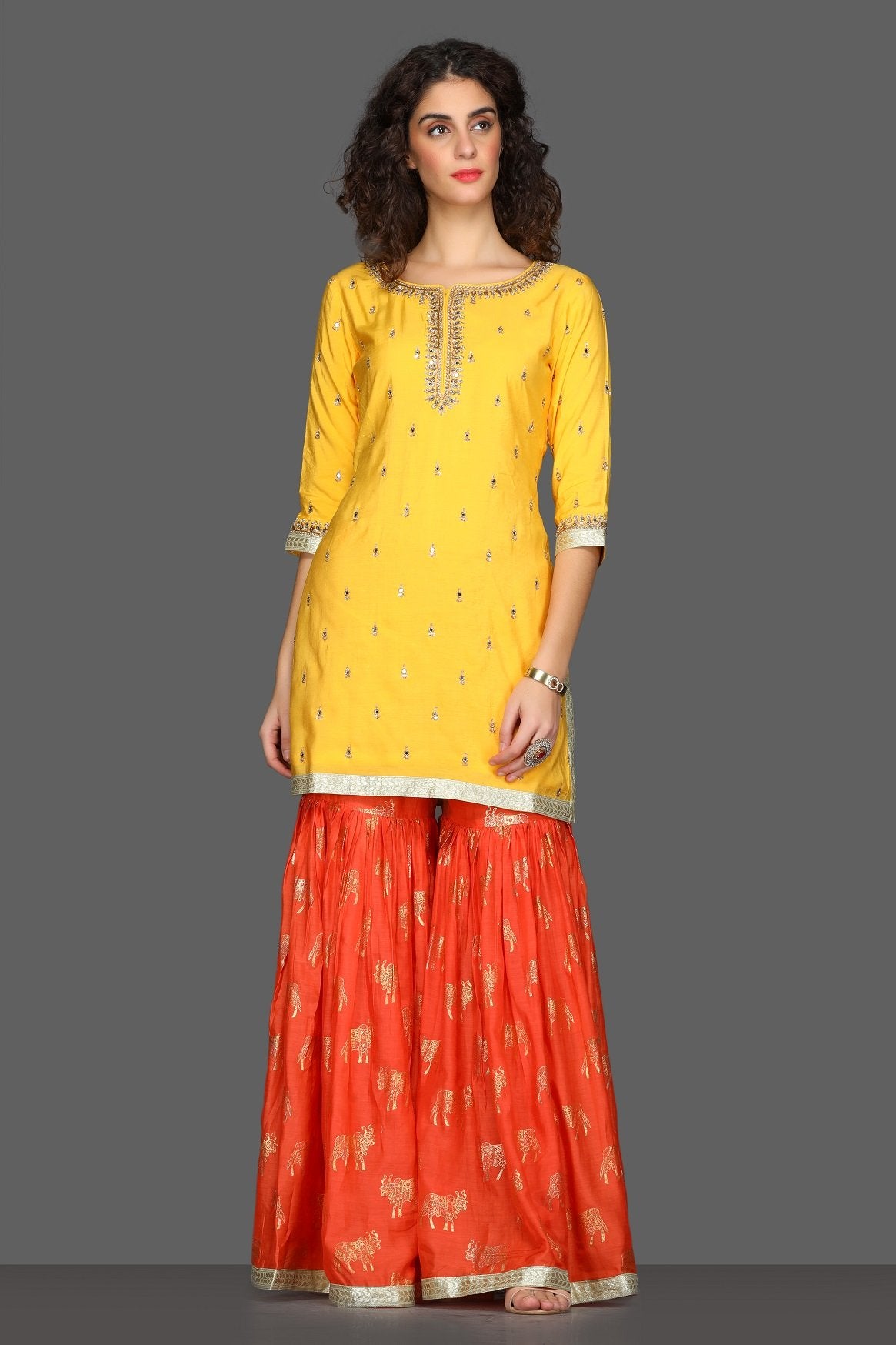 Buy bright yellow and red embroidered sharara suit online in USA with printed dupatta. Dazzle on weddings and special occasions with exquisite Indian designer dresses, sharara suits, Anarkali suits from Pure Elegance Indian fashion store in USA.-front