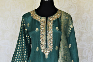 Shop dark green embroidered silk palazzo suit online in USA with dupatta. Elevate your ethnic style on weddings and festive occasions with stunning designer Anarkali suits, sharara suits, palazzo suits, salwar suits from Pure Elegance Indian fashion boutique in USA.-front