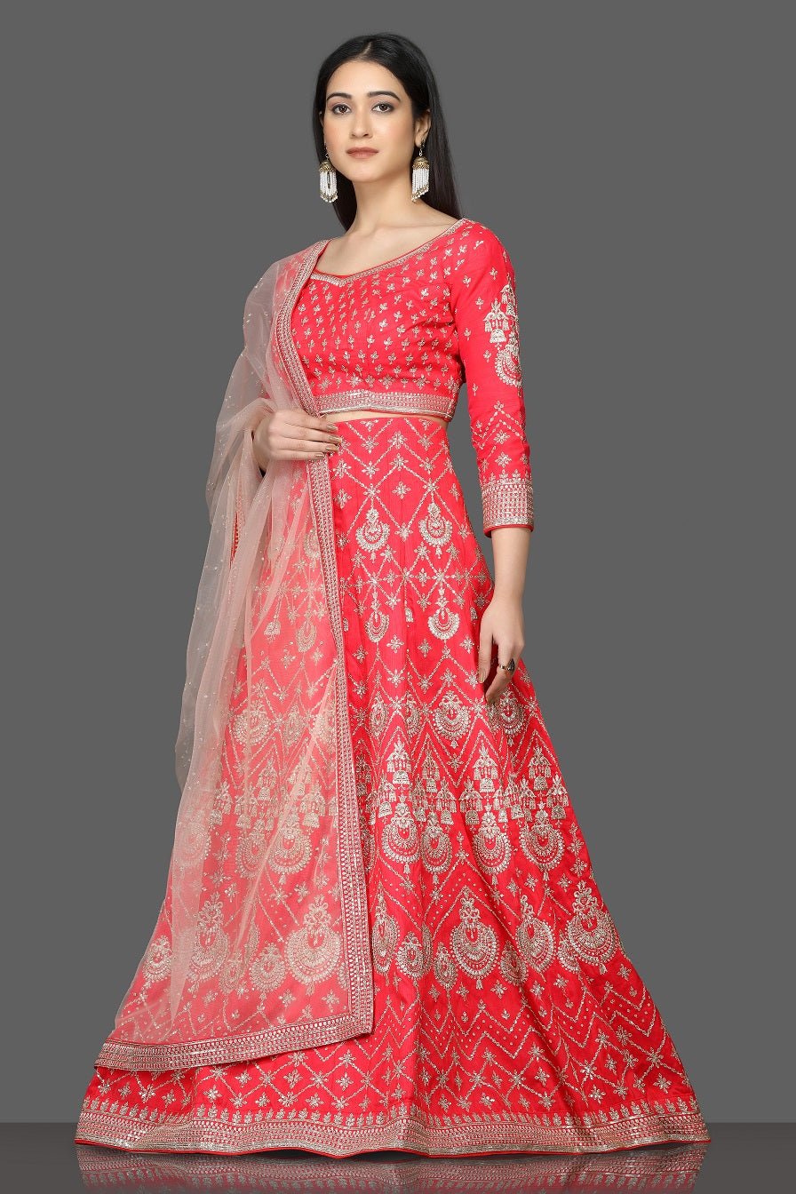 Buy stunning tomato red embroidered designer lehenga online in USA with net dupatta. Flaunt your sartorial choices on special occasions with beautiful designer gowns, Anarkali suits, traditional salwar suits, Indian lehengas from Pure Elegance Indian fashion boutique in USA. -left