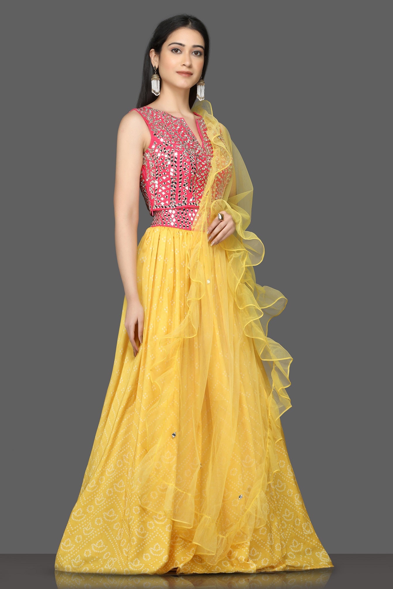 Buy gorgeous pink and yellow mirror work lehenga online in USA with ruffle dupatta. Flaunt your sartorial choices on special occasions with beautiful designer gowns, Anarkali suits, traditional salwar suits, Indian lehengas from Pure Elegance Indian fashion boutique in USA. -right