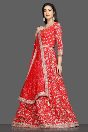 Shop beautiful tomato red embroidered lehenga online in USA with net dupatta. Flaunt your sartorial choices on special occasions with beautiful designer gowns, Anarkali suits, traditional salwar suits, Indian lehengas from Pure Elegance Indian fashion boutique in USA. -left