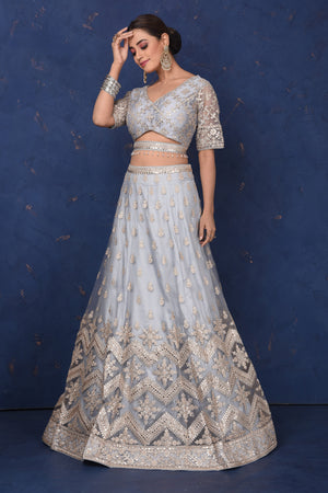 Buy beautiful light grey embroidered net lehenga online in USA with dupatta, Be the center of attraction on festive occasions in beautiful designer suits, dresses, lehengas, designer gowns, from Pure Elegance Indian fashion store in USA.-front