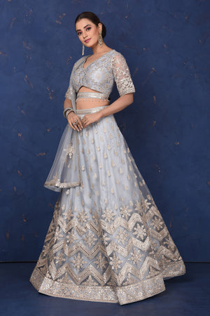 Buy beautiful light grey embroidered net lehenga online in USA with dupatta, Be the center of attraction on festive occasions in beautiful designer suits, dresses, lehengas, designer gowns, from Pure Elegance Indian fashion store in USA.-left