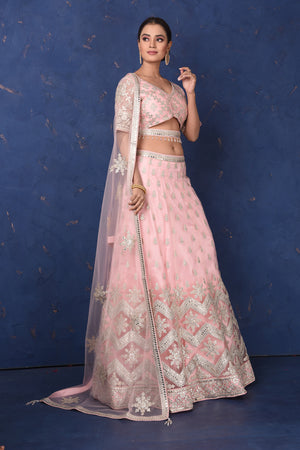 Shop powder pink embroidered net lehenga online in USA with dupatta, Be the center of attraction on festive occasions in beautiful designer suits, dresses, lehengas, designer gowns, from Pure Elegance Indian fashion store in USA.-left