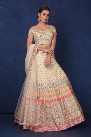 Buy stunning cream embroidered designer off-shoulder lehenga online in USA with dupatta. Set fashion goals on special occasions in exclusive designer lehengas, Indian suits, Anarkali dresses, designer gowns, bridal lehengas from Pure Elegance Indian fashion store in USA.-closeup