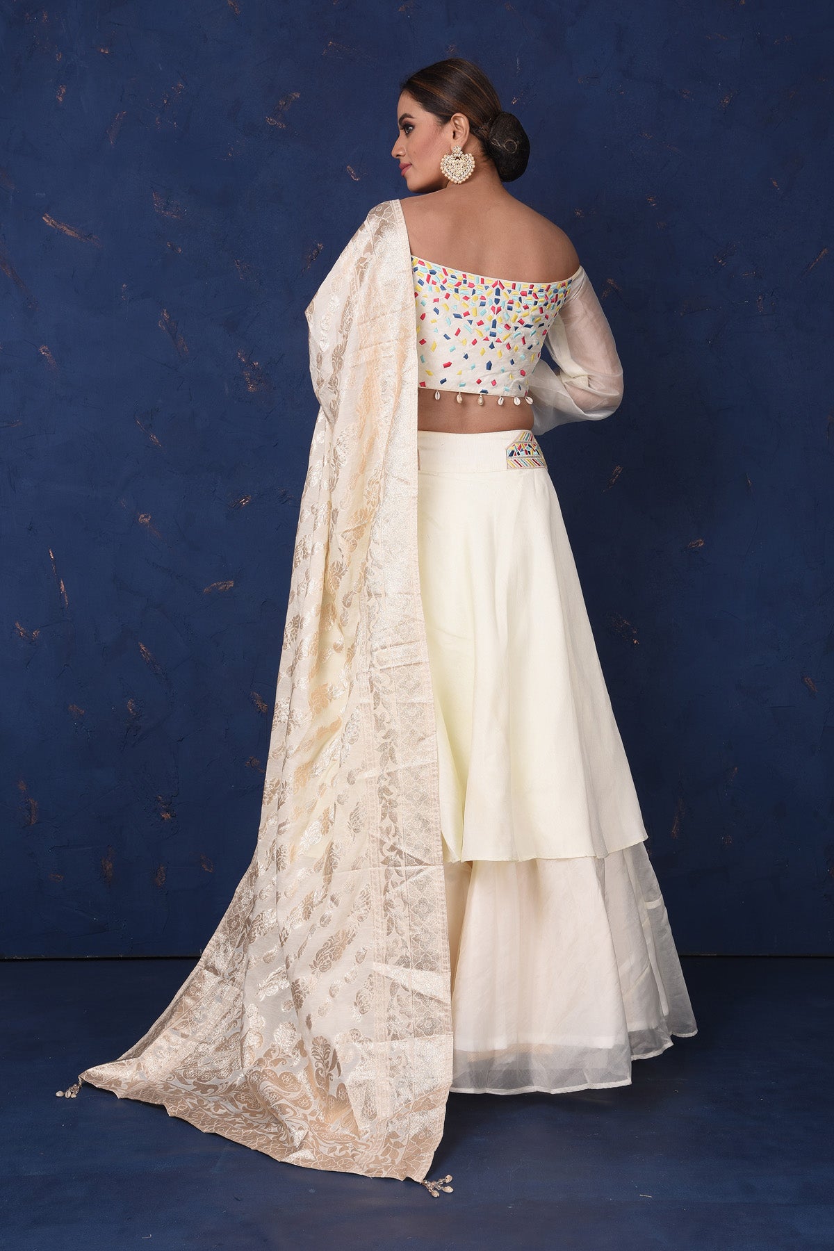 Shop elegant cream embroidered off-shoulder designer lehenga online in USA with dupatta. Set fashion goals on special occasions in exclusive designer lehengas, Indian suits, Anarkali dresses, designer gowns, bridal lehengas from Pure Elegance Indian fashion store in USA.-back