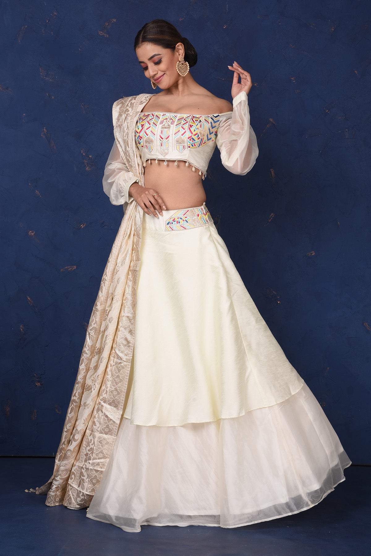 Shop elegant cream embroidered off-shoulder designer lehenga online in USA with dupatta. Set fashion goals on special occasions in exclusive designer lehengas, Indian suits, Anarkali dresses, designer gowns, bridal lehengas from Pure Elegance Indian fashion store in USA.-skirt