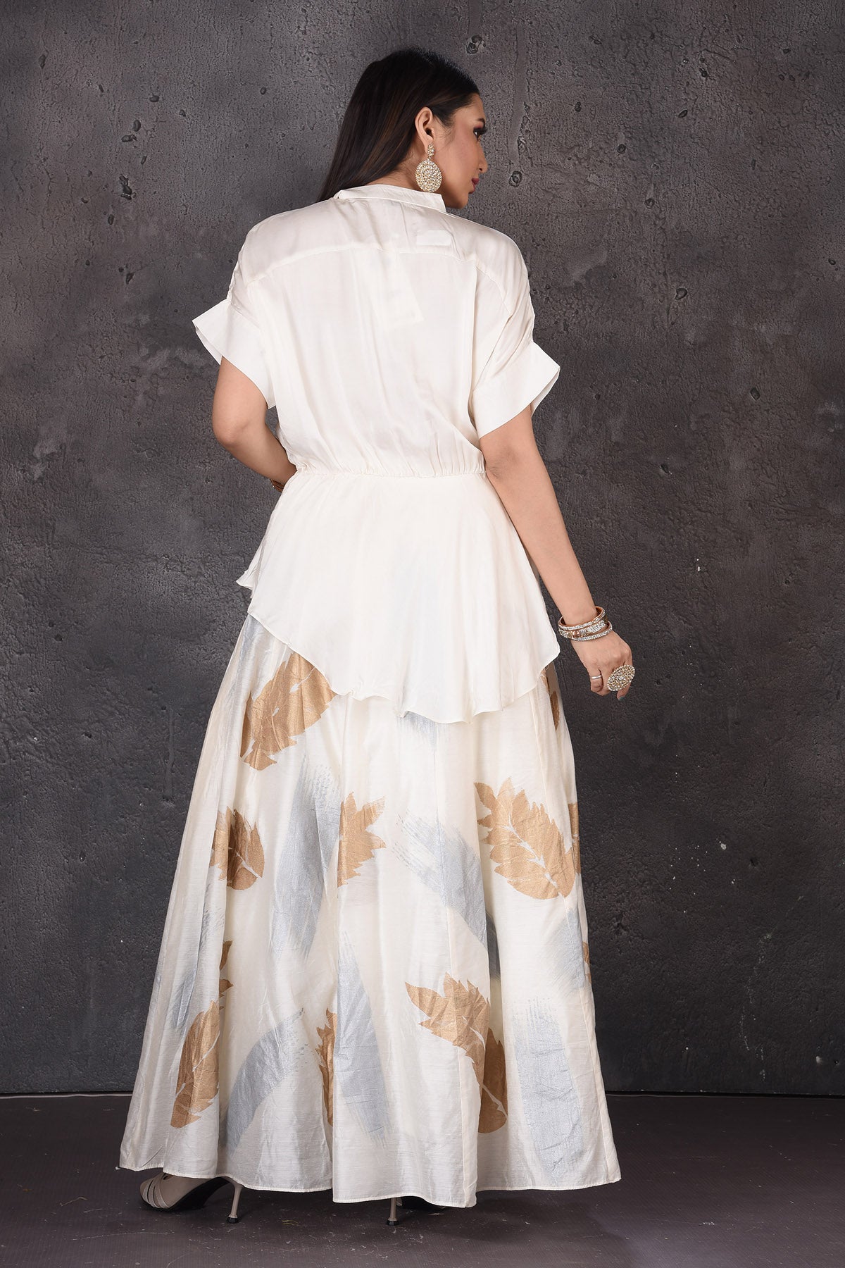 Shop stunning white skirt set online in USA with golden leaf print. Look elegant at weddings and festive occasions in exclusive designer suits, designer gowns, Anarkali suits, sharara suits, bridal gowns, palazzo suits, designer lehenga from Pure Elegance Indian clothing store in USA.-back