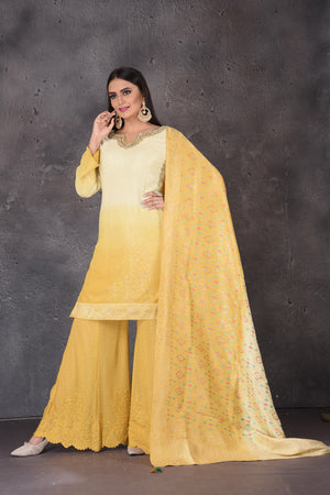 Buy stunning yellow embroidered sharara suit online in USA with dupatta. Look elegant at weddings and festive occasions in exclusive designer suits, designer gowns, Anarkali suits, sharara suits, bridal gowns, palazzo suits, designer lehenga from Pure Elegance Indian clothing store in USA.-front