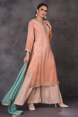 Buy stunning peach embroidered palazzo suit online in USA with blue dupatta. Look elegant at weddings and festive occasions in exclusive designer suits, designer gowns, Anarkali suits, sharara suits, bridal gowns, palazzo suits, designer lehenga from Pure Elegance Indian clothing store in USA.-palazzo