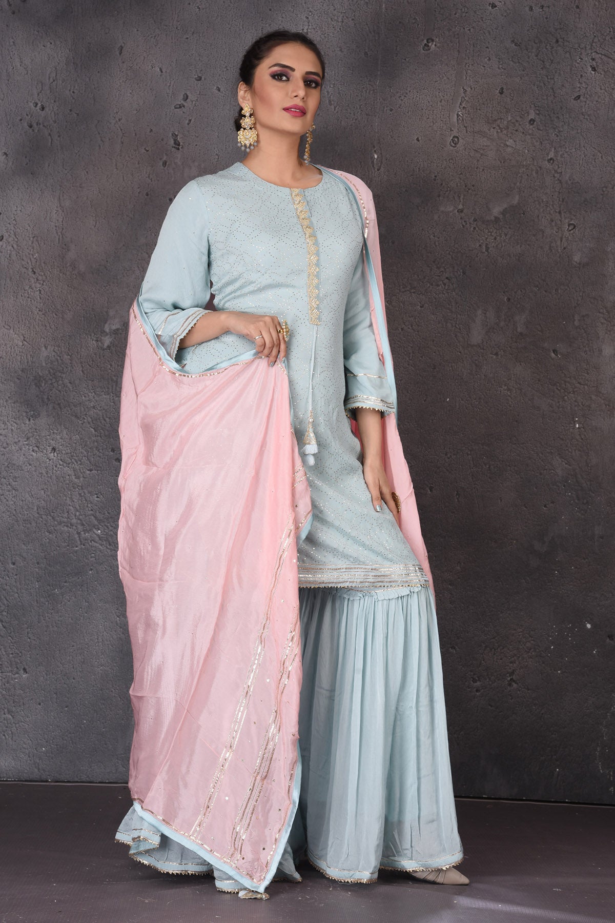 Buy beautiful pastel blue embroidered sharara suit online in USA with pink dupatta. Look elegant at weddings and festive occasions in exclusive designer suits, designer gowns, Anarkali suits, sharara suits, wedding gowns, palazzo suits, designer lehenga from Pure Elegance Indian clothing store in USA.-front