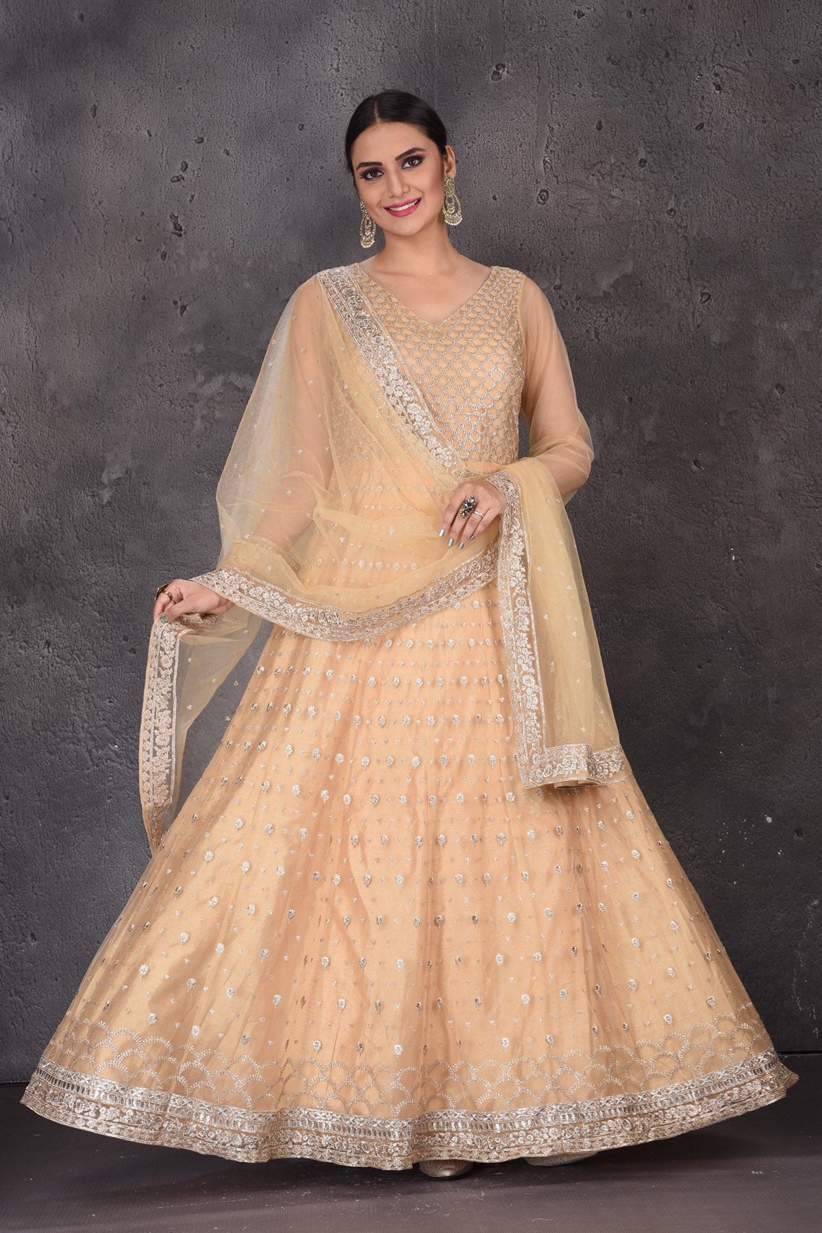 Shop beautiful peach embroidered net Anarkali suit online in USA with dupatta. Look elegant at weddings and festive occasions in exclusive designer suits, designer gowns, Anarkali suits, sharara suits, wedding gowns, palazzo suits, designer lehenga from Pure Elegance Indian clothing store in USA.-full view