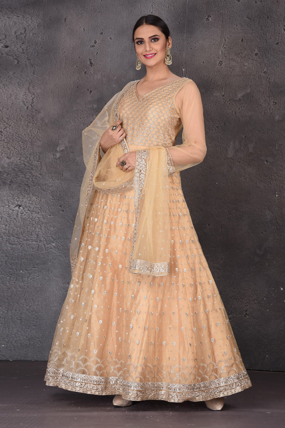 Shop beautiful peach embroidered net Anarkali suit online in USA with dupatta. Look elegant at weddings and festive occasions in exclusive designer suits, designer gowns, Anarkali suits, sharara suits, wedding gowns, palazzo suits, designer lehenga from Pure Elegance Indian clothing store in USA.-left