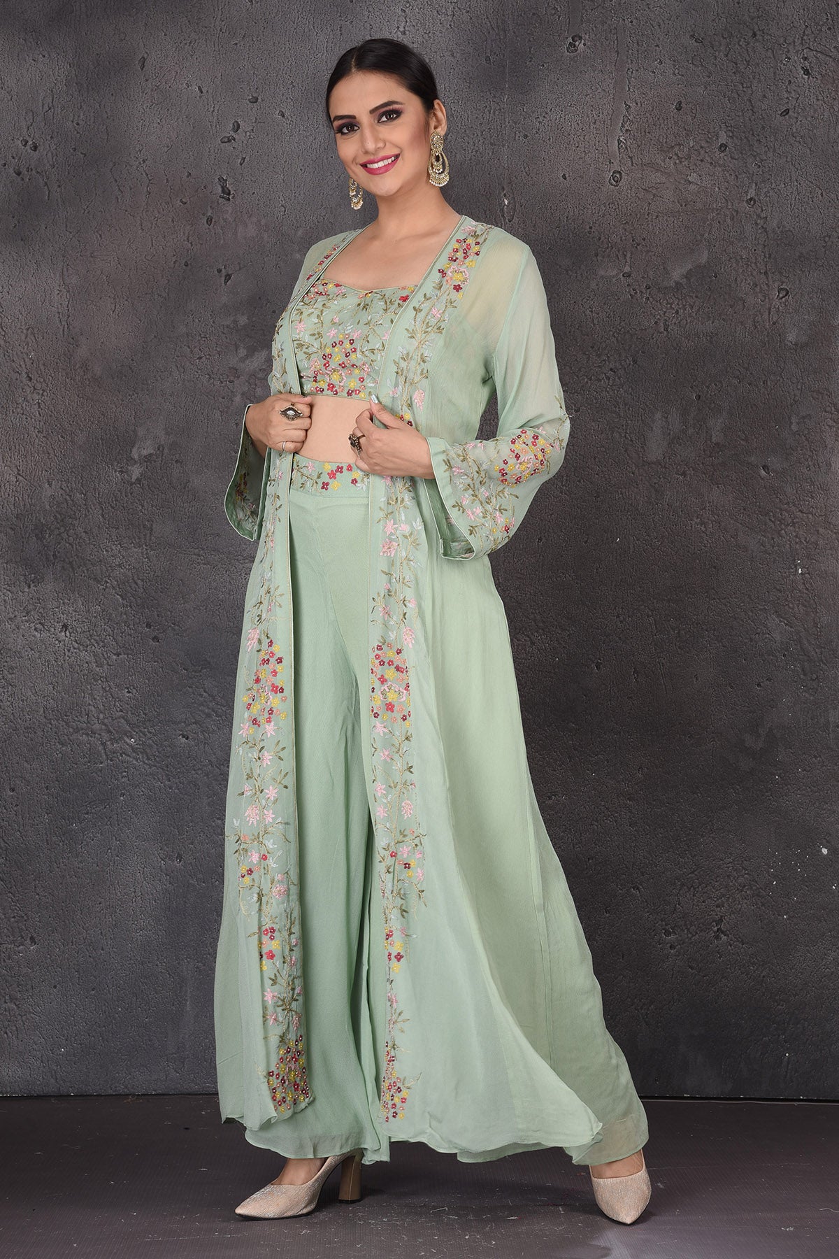 Buy sage green embroidered crop top online in USA with palazzo and shrug. Look elegant at weddings and festive occasions in exclusive designer suits, designer gowns, Anarkali suits, sharara suits, wedding gowns, palazzo suits, designer lehenga from Pure Elegance Indian clothing store in USA.-left