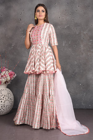 Buy cream printed peplum sharara suit online in USA with dupatta. Set a fashion statement at parties in designer dresses, Anarkali suits, designer lehengas, gowns, Indowestern dresses from Pure Elegance Indian fashion store in USA.-left