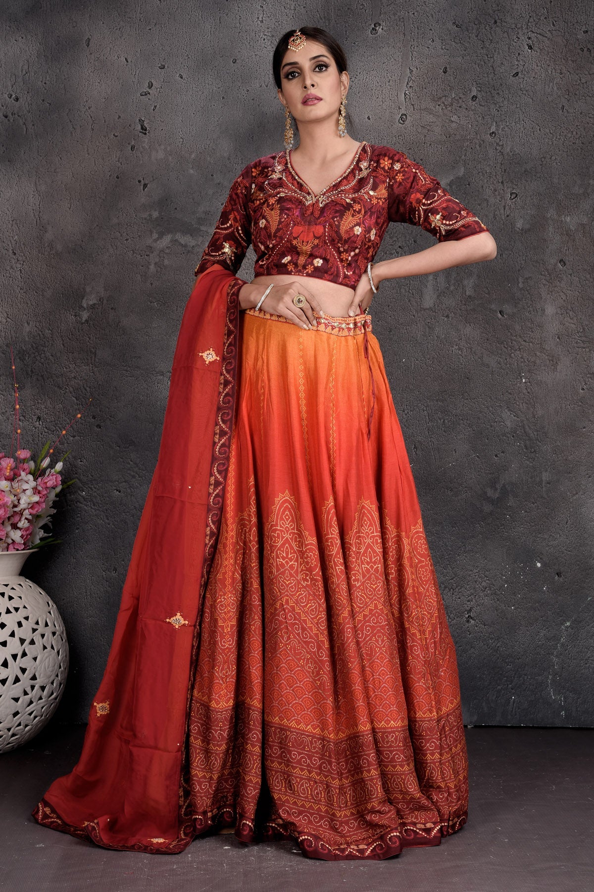 Buy maroon and orange printed and embroidered lehenga online in USA with dupatta. Set a fashion statement at parties in designer Indian suits, Anarkali suits, designer lehengas, gowns, Indowestern dresses from Pure Elegance Indian fashion store in USA.-front