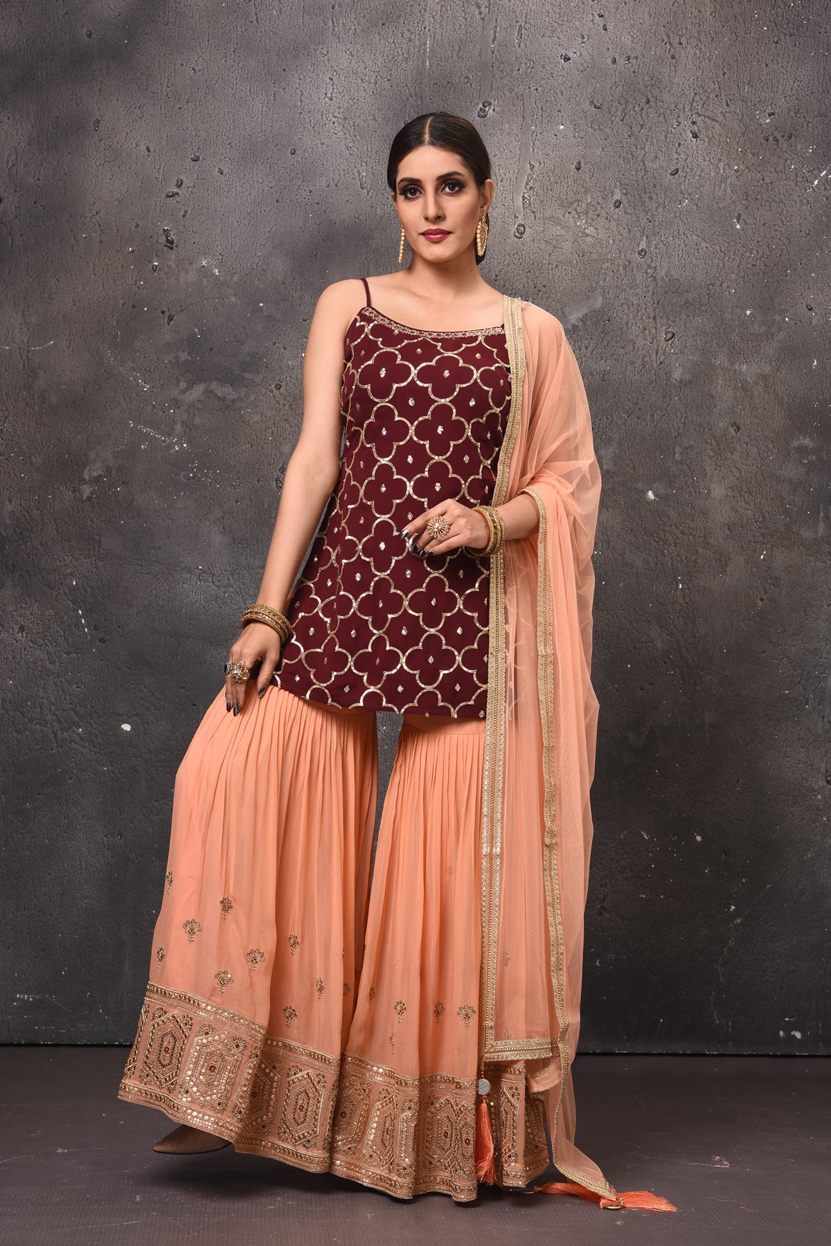 Buy stunning maroon and peach embroidered sharara suit online in USA. Get set for weddings and festive occasions in exclusive designer Anarkali suits, wedding gown, salwar suits, gharara suits, Indowestern dresses from Pure Elegance Indian fashion store in USA.-full view