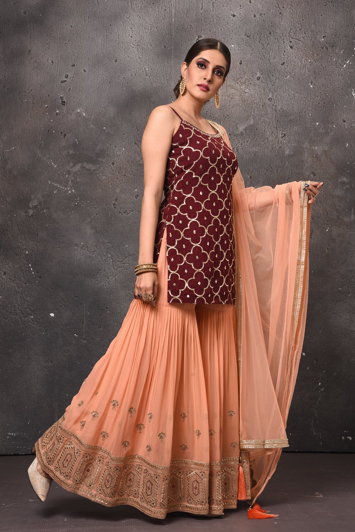 Buy stunning maroon and peach embroidered sharara suit online in USA. Get set for weddings and festive occasions in exclusive designer Anarkali suits, wedding gown, salwar suits, gharara suits, Indowestern dresses from Pure Elegance Indian fashion store in USA.-side