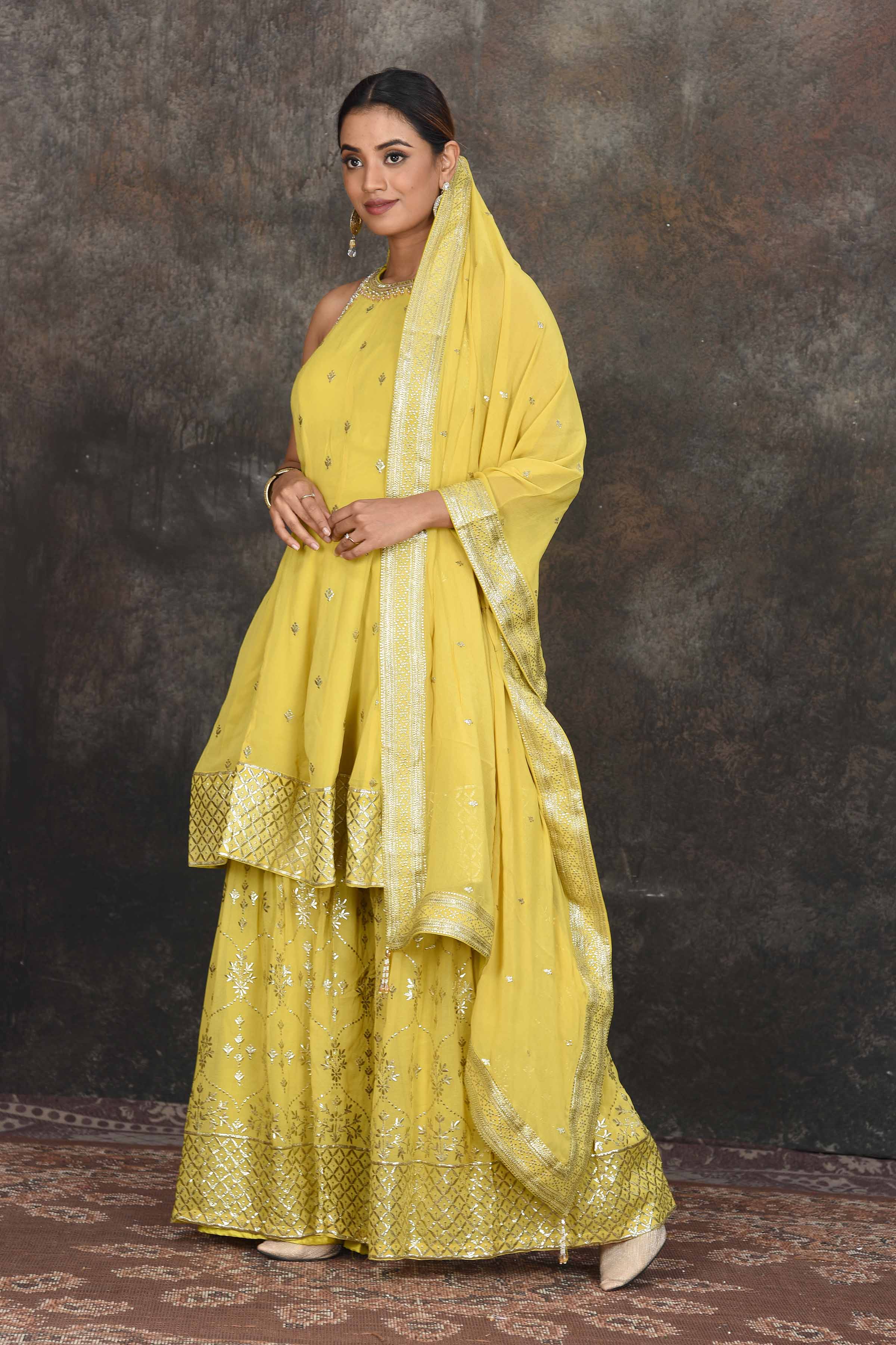 Shop stunning yellow halter neck embroidered sharara suit online in USA with dupatta. Dazzle at sangeet and wedding occasions in this beautiful designer lehengas, Anarkali suits, sharara suit, bridal gowns, bridal lehengas from Pure Elegance Indian fashion store in USA.-side