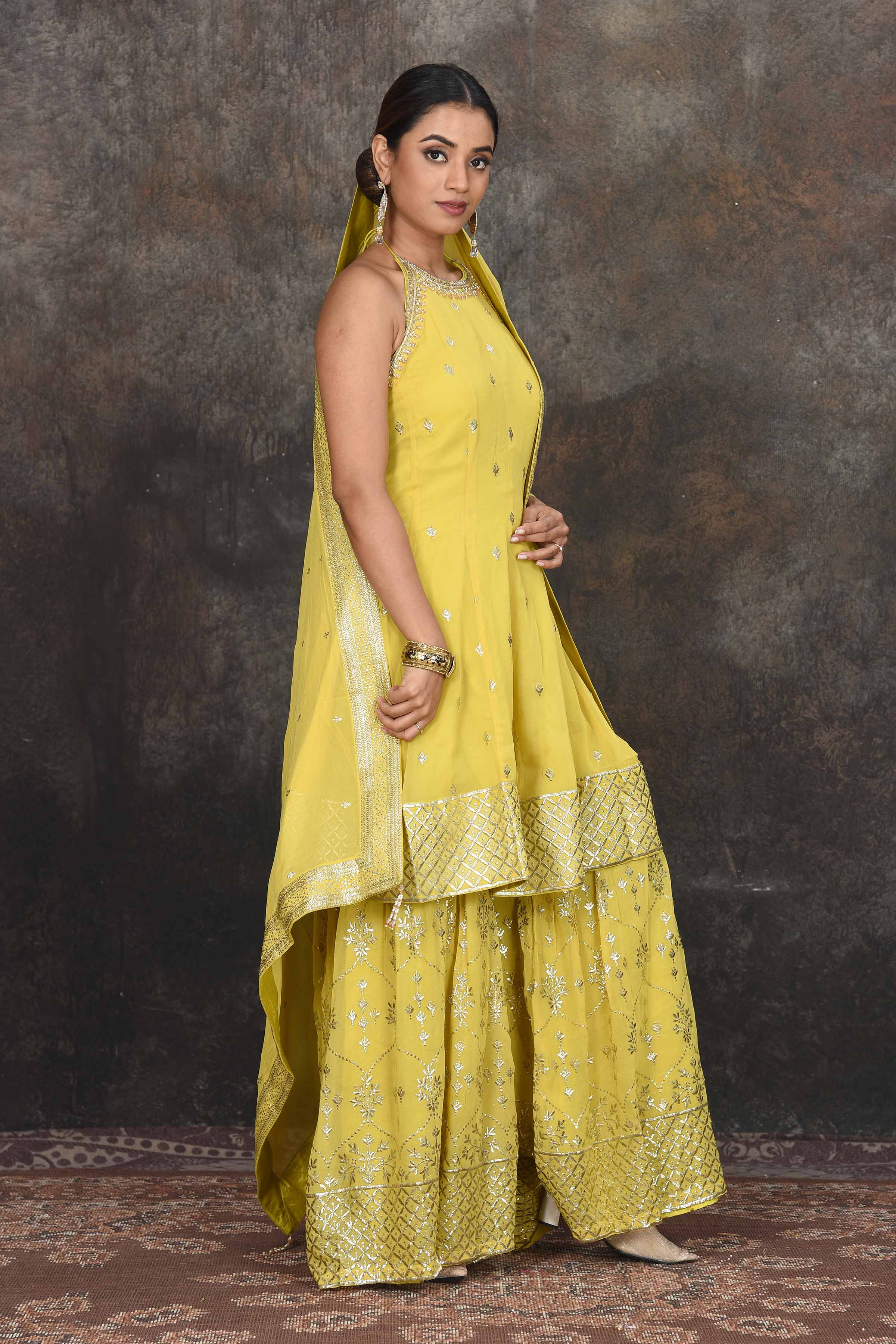 Shop stunning yellow halter neck embroidered sharara suit online in USA with dupatta. Dazzle at sangeet and wedding occasions in this beautiful designer lehengas, Anarkali suits, sharara suit, bridal gowns, bridal lehengas from Pure Elegance Indian fashion store in USA.-right