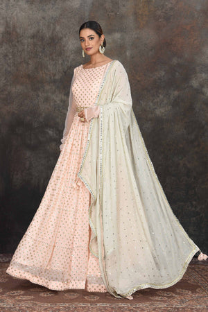 Buy beautiful light peach embroidered Anarkali suit online in USA with mint green embroidered dupatta. Dazzle at sangeet and wedding occasions in this beautiful designer lehengas, Anarkali suits, sharara suit, bridal gowns, bridal lehengas from Pure Elegance Indian fashion store in USA.-left