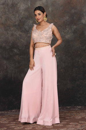 Buy stunning powder pink applique work crop top online in USA with palazzo. Dazzle at sangeet and wedding occasions in this beautiful designer lehengas, Anarkali suits, sharara suit, bridal gowns, bridal lehengas from Pure Elegance Indian fashion store in USA.-left