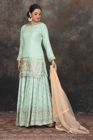 Shop beautiful mint green embroidered sharara suit online in USA with peach dupatta. Dazzle at sangeet and wedding occasions in this beautiful designer lehengas, Anarkali suits, sharara suit, bridal gowns, bridal lehengas from Pure Elegance Indian fashion store in USA.-side