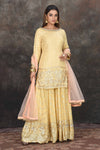 Buy beautiful lemon yellow embroidered sharara suit online in USA with peach dupatta. Dazzle at sangeet and wedding occasions in this beautiful designer lehengas, Anarkali suits, sharara suit, bridal gowns, bridal lehengas from Pure Elegance Indian fashion store in USA.-full view