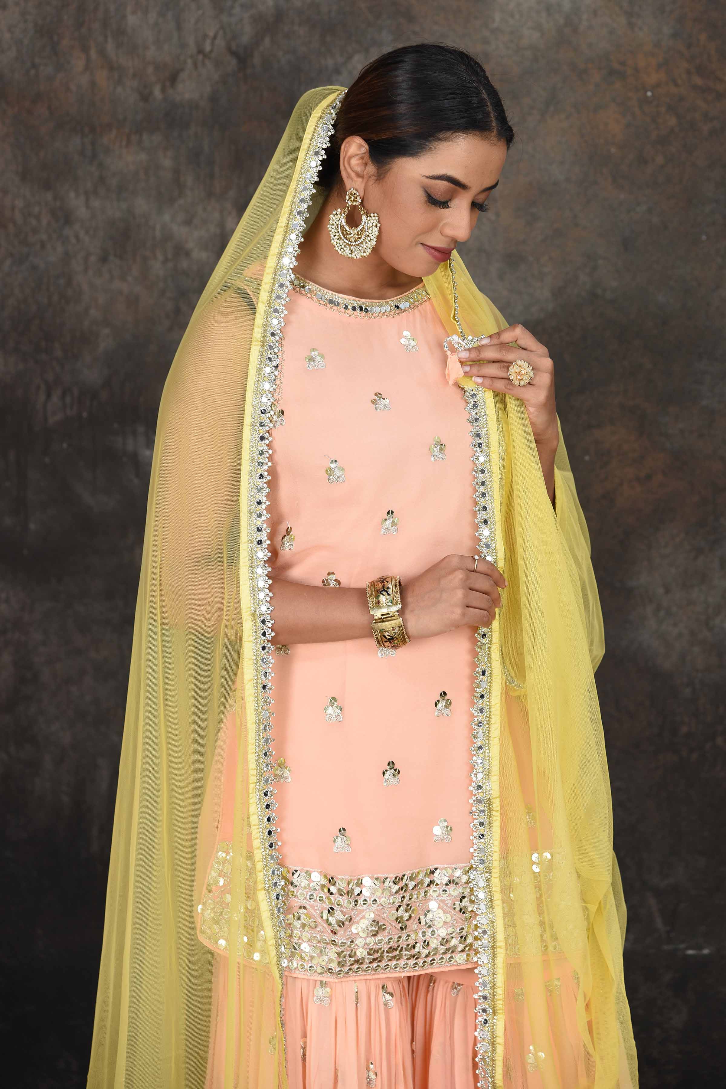 Shop beautiful peach embroidered sharara suit online in USA with yellow dupatta. Dazzle at sangeet and wedding occasions in this beautiful designer lehengas, Anarkali suits, sharara suit, bridal gowns, bridal lehengas from Pure Elegance Indian fashion store in USA.-closeup