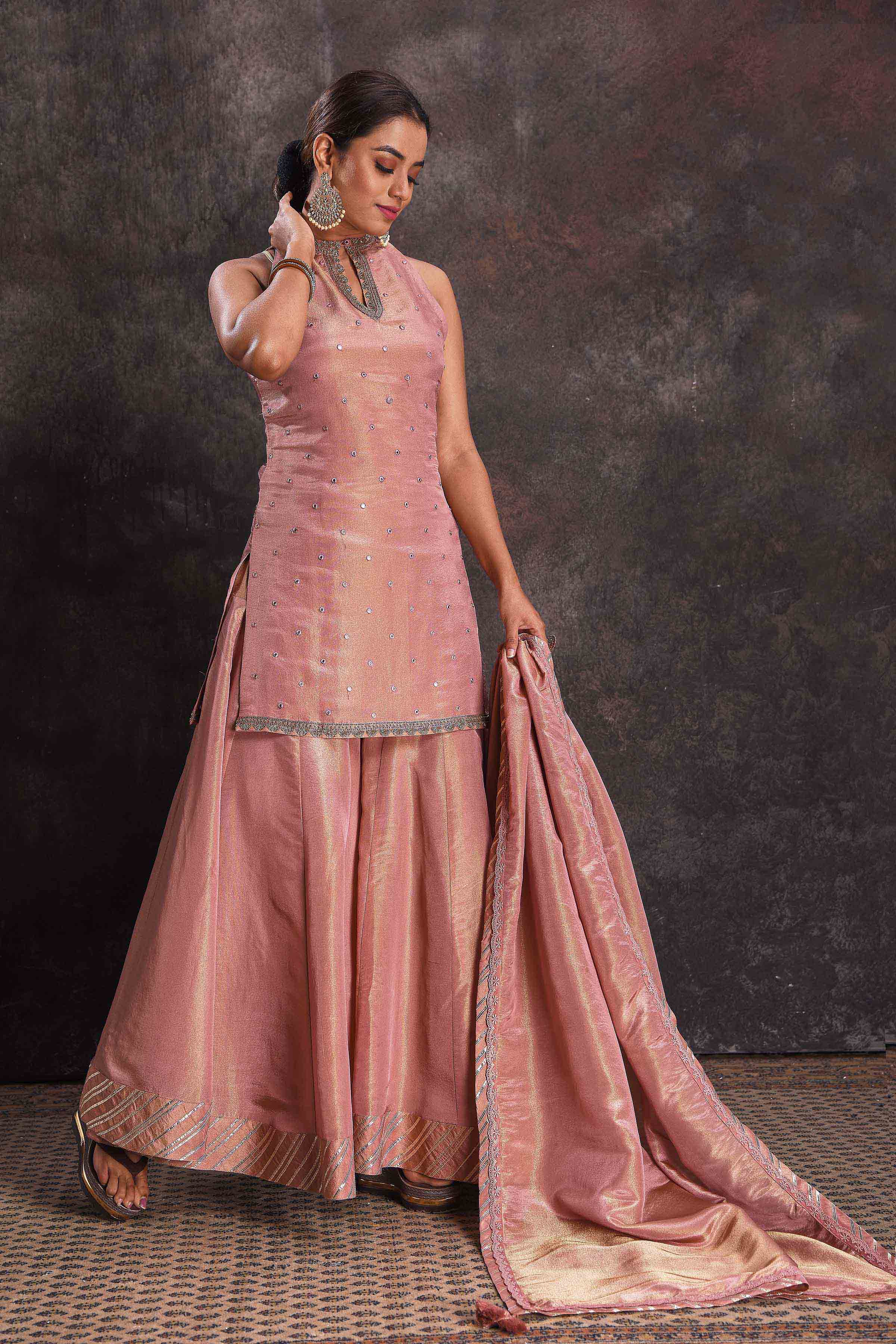 Buy stunning golden pink mirror work sharara suit online in USA with dupatta. Look your ethnic best on festive occasions with latest designer sarees, pure silk sarees, Kanchipuram silk sarees, designer dresses, Anarkali suits, gown, embroidered sarees from Pure Elegance Indian fashion store in USA.-front