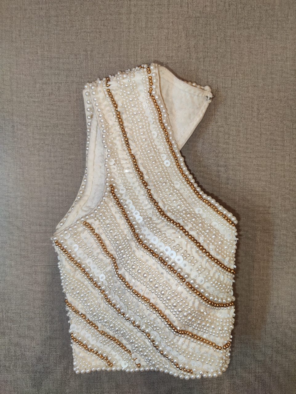 Buy beautiful off-white bead and shell work sleeveless saree blouse online in USA. Elevate your Indian saree style with exquisite readymade sari blouse, embroidered saree blouses, Banarasi saree blouse, designer sari blouse, choli-cut blouses from Pure Elegance Indian clothing store in USA.-side