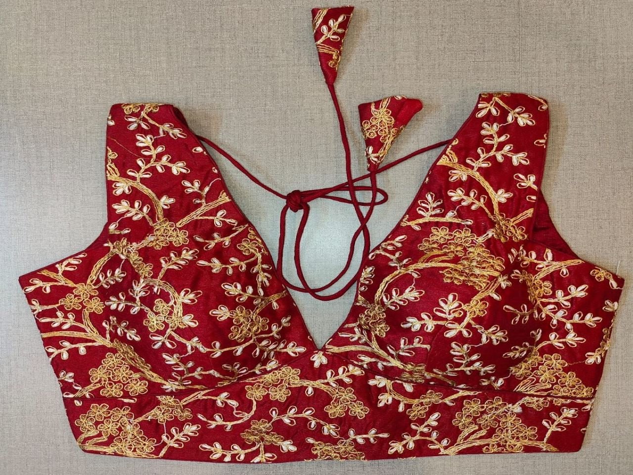 Buy maroon padded saree blouse online in USA with golden embroidery. Elevate your Indian saree style with exquisite readymade sari blouse, embroidered saree blouses, Banarasi saree blouse, designer sari blouse, choli-cut blouses from Pure Elegance Indian clothing store in USA.-full view