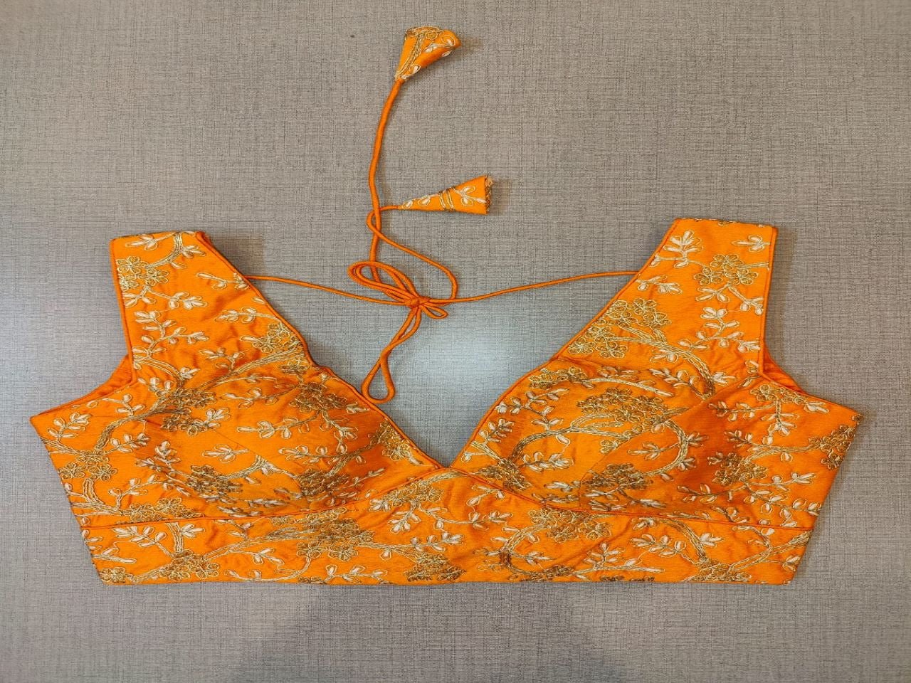 Buy beautiful orange sleeveless saree blouse online in USA with golden embroidery. Elevate your Indian saree style with exquisite readymade sari blouse, embroidered saree blouses, Banarasi saree blouse, designer sari blouse, choli-cut blouses from Pure Elegance Indian clothing store in USA.-Front