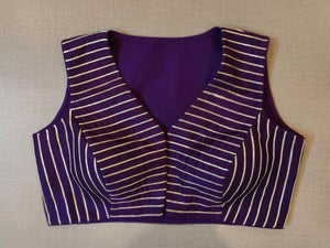 Buy Festive essentials and get an elevated twist with this purple-striped blouse. Featuring a golden strip, the blouse is cut with, V-neck, and is sleeveless. Wear it with a contrasting saree or even with a contrasting lehenga skirt to complete the look. Elevate your Indian saree style with exquisite readymade sari blouses, embroidered saree blouses, Banarasi sari blouses, and designer sari blouse from Pure Elegance Indian clothing store in the USA.- Front View