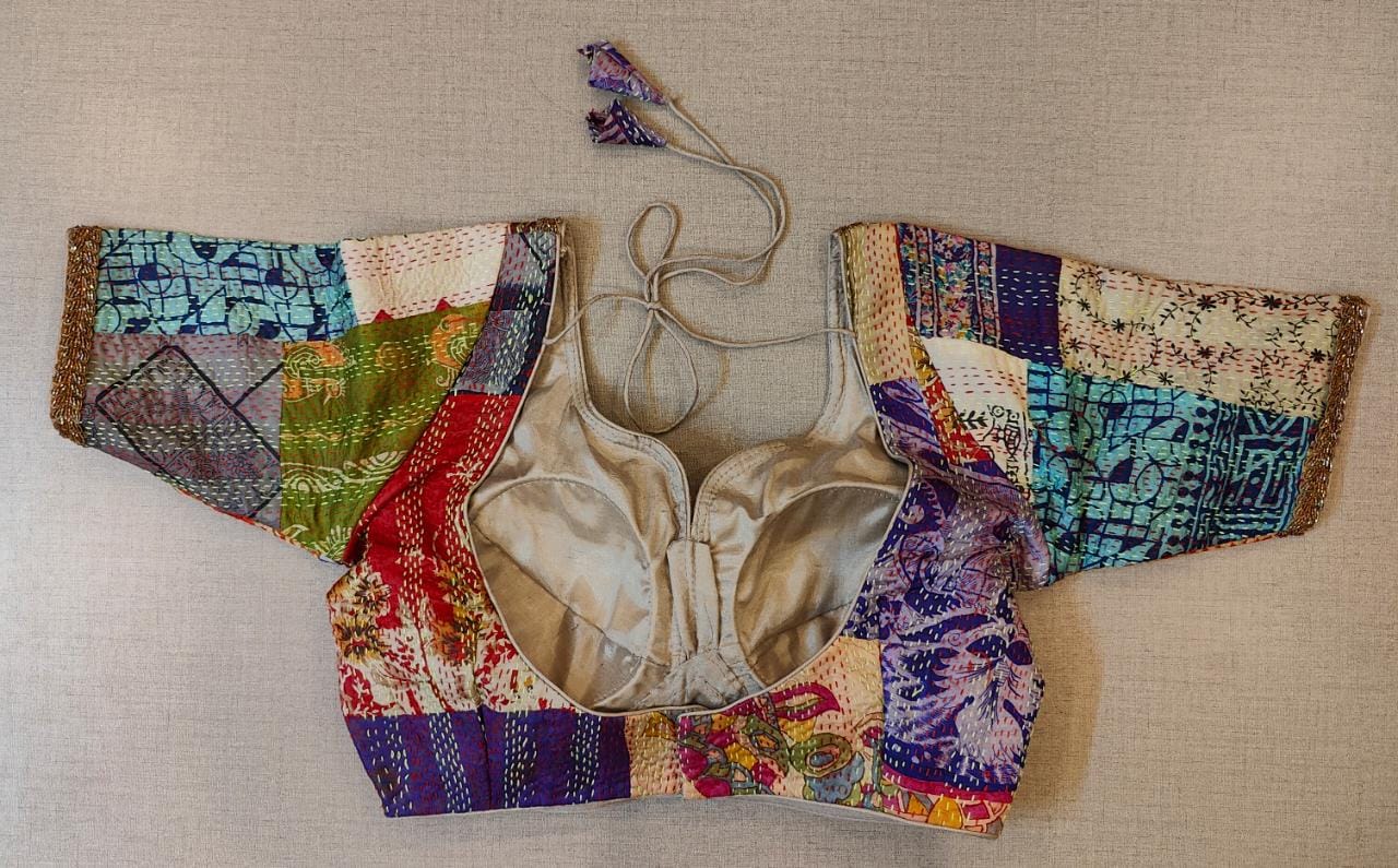 Buy an off-white multicolor printed padded saree blouse, that has a V-neck, short sleeves, tie-up detail at the back, hook, and eye closure. Let your aura shine throughout by wearing this designer saree blouse. Pair this fashionable blouse with a beautiful printed sari and statement neck piece and you are good to go.- Back View