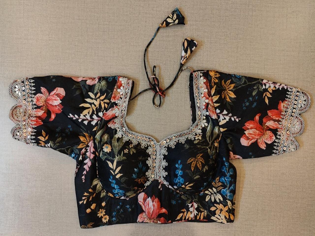 Buy & Give your ethnic look a dazzling update with this black blouse. Tailored in silk, it features 3/4th sleeves, floral embroidery, a V-neck in the front, and hook closure at the back details. Pair it with a complementary solid sari and diamond stud earrings. Elevate your Indian saree style with exquisite readymade sari blouses, embroidered saree blouses, Banarasi sari blouses, and designer sari blouses from Pure Elegance Indian clothing store in the USA.- Front View