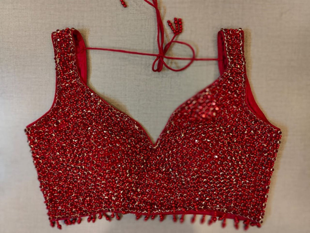 Buy a tailored in a timeless hue and topped with elegant pearl & sequin details, this Maroon blouse is an evergreen addition to your festive wardrobe and party look. It is designed with a V neckline, sleeveless, and back hook closure with a tie-up. Buy this designer blouse in the USA from Pure Elegance. - Front View