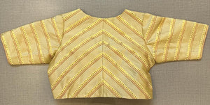Buy a tailored in a timeless hue and topped with stripped details, this golden blouse is an evergreen addition to your festive wardrobe and party look. It is designed with a V neckline, 3/4th sleeves, and back hook closure. Buy this designer blouse in the USA from Pure Elegance. - Back View