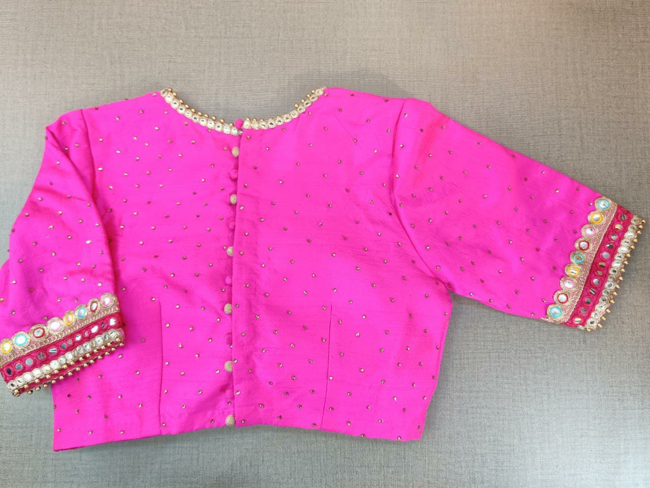 Shop beautiful neon pink embroidered saree blouse online in USA with mirror work. Elevate your Indian ethnic sari looks with exquisite readymade saree blouse, embroidered saree blouses, Banarasi saree blouse, designer saree blouse from Pure Elegance Indian clothing store in USA.-back