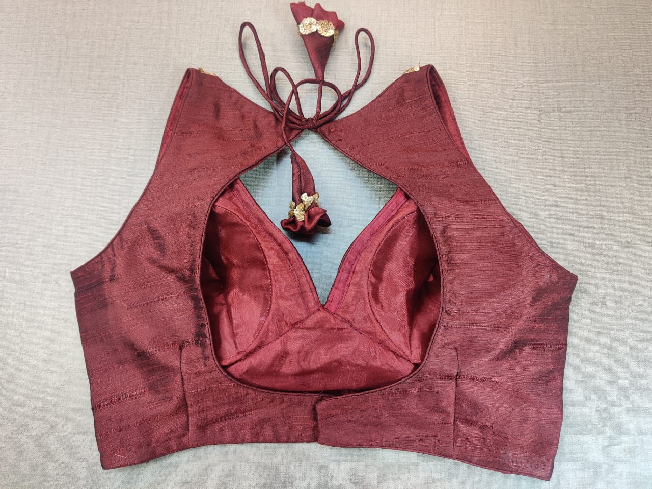 Buy stunning maroon sleeveless sari blouse online in USA with sequin work neckline. Elevate your Indian ethnic saree looks with beautiful readymade sari blouse, embroidered saree blouses, Banarasi saree blouse, designer saree blouse from Pure Elegance Indian clothing store in USA.-back