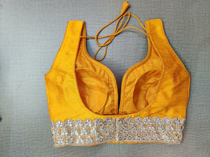 Buy beautiful yellow sleeveless saree blouse online in USA with lace border. Elevate your Indian ethnic saree looks with beautiful readymade saree blouse, embroidered saree blouses, Banarasi saree blouse, designer saree blouses from Pure Elegance Indian fashion store in USA.-back