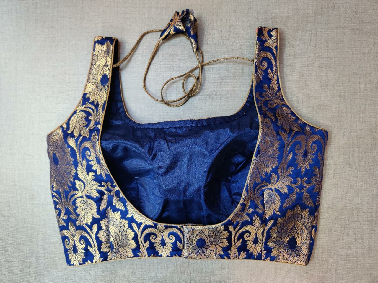 Buy stunning dark blue sleeveless Banarasi sari blouse online in USA. Elevate your Indian ethnic saree looks with beautiful readymade sari blouse, embroidered saree blouses, Banarasi saree blouse, designer sari blouses, sleeveless saree blouses from Pure Elegance Indian fashion store in USA.-back
